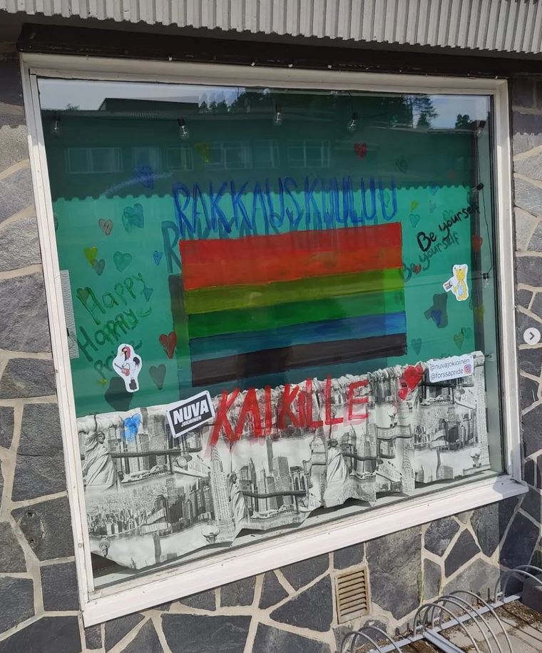 ikkunaan maalattu sateenkaarilippu, ympärillä teksti "Rakkaus kuuluu kaikille"